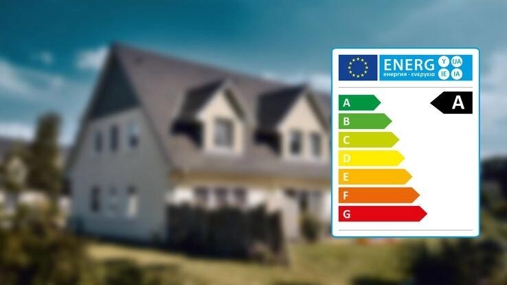 Im Vordergrund sieht man das Energieeffizienzlabel und im Hintergrund ein Einfamilienhaus.