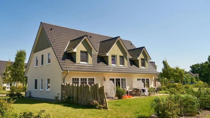 Auf dem Bild ist ein Reihenhaus mit den dazugehörigen Gärten abgebildet.