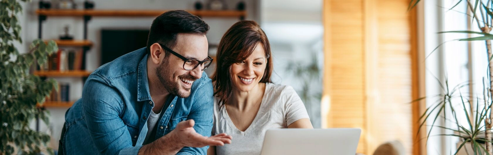 Zwei Personen sitzen vor einem Laptop und schauen ihre SCHUFA an.