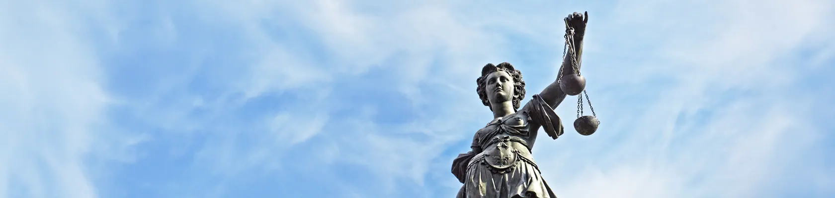Eine Statue der Justitia steht symbolisch für das Thema Steuern und Recht beim Immobilienkauf.