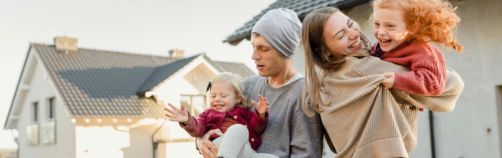 Symbolbild für KfW 300: Eine junge Familie steht vor ihrem Eigenheim.