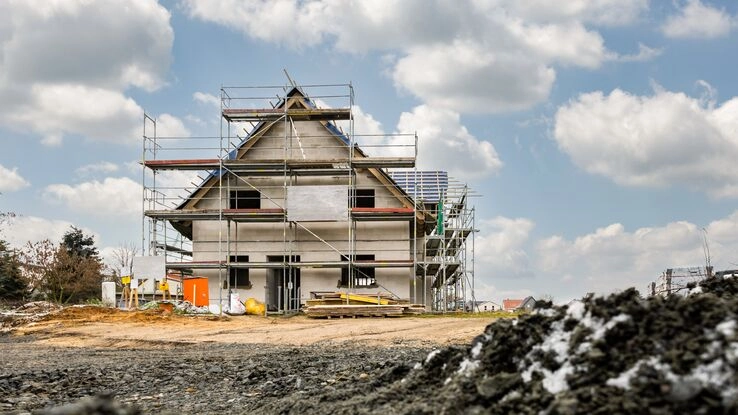Ein Haus im Bau, um das ein Gerüst steht.