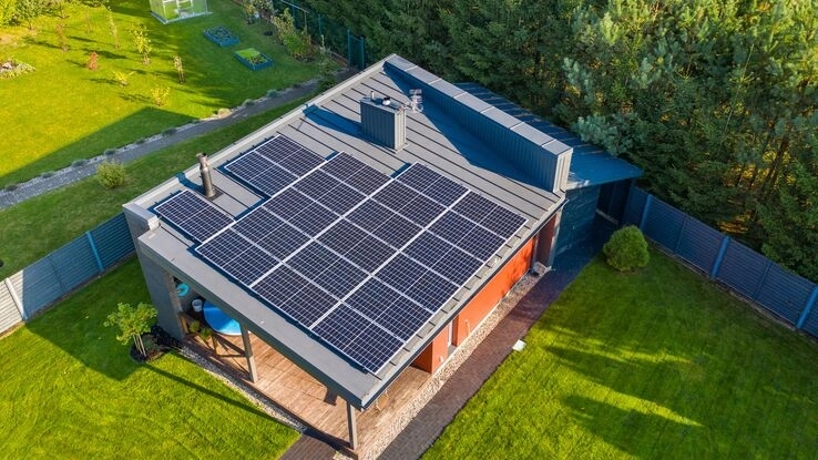 Eine Solaranlage auf dem Dach eines kleinen Hauses.