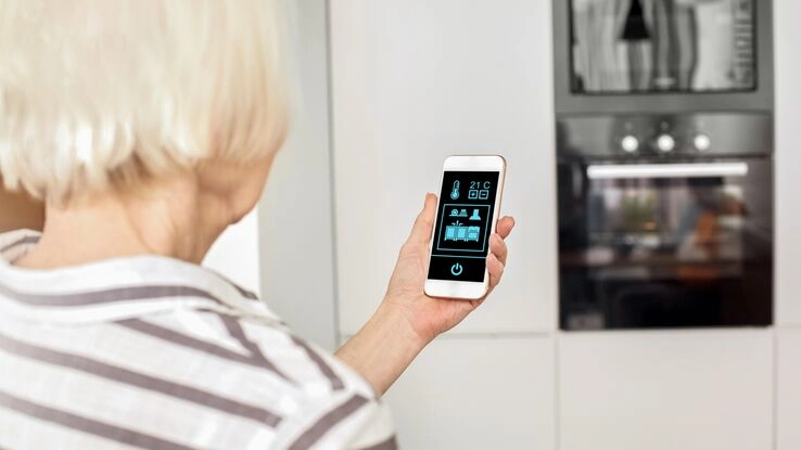 Eine Frau nutzt eine Smart Home Technologie, welche das Leben im Alter vereinfachen kann.