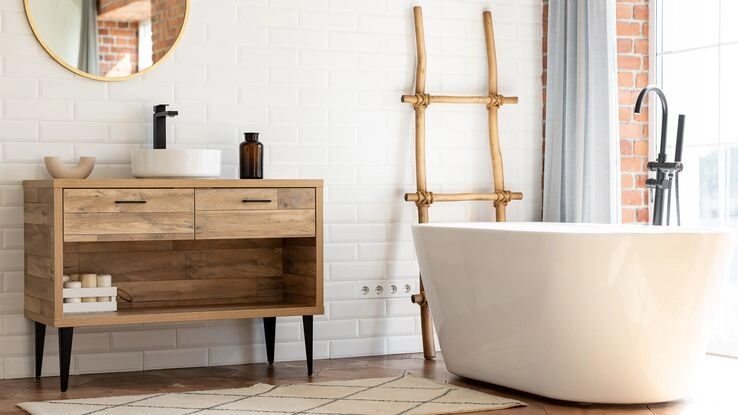 Ein nachhaltig und natürlich dekoriertes Badezimmer mit einer freistehenden Badewanne und einem Holzwaschtisch
