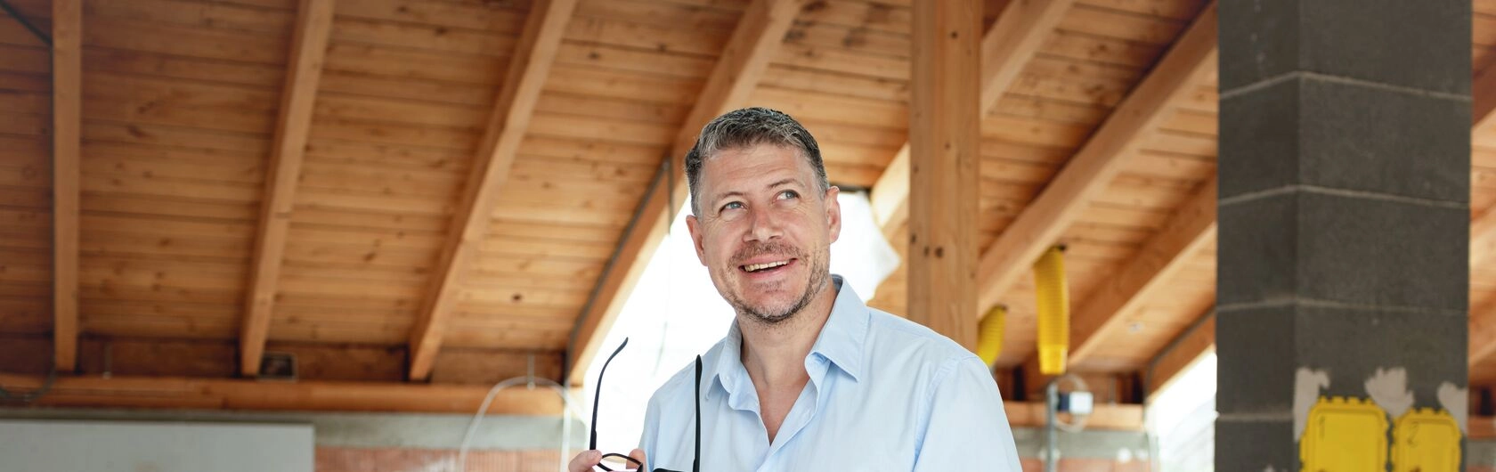 Im Bild sieht man einen Mann, der sich Gedanken über Informationen und Tipps zum Thema Holzdecke modernisieren macht.