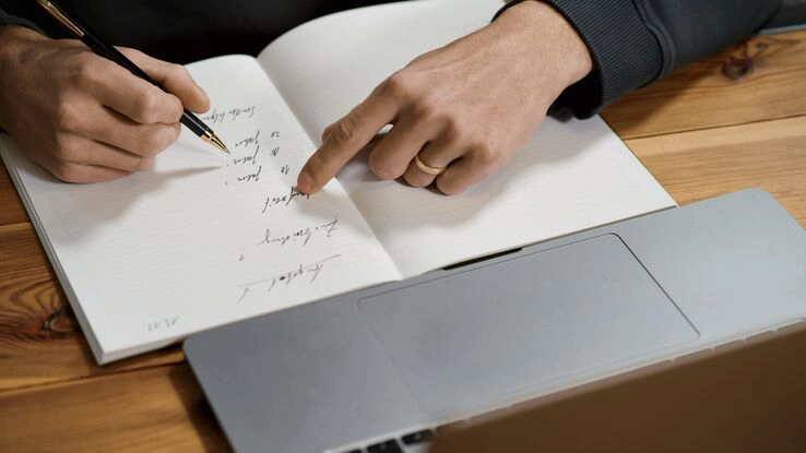 Eine Person dokumentiert Mängel an der Mietwohnung in seinem Notizbuch.