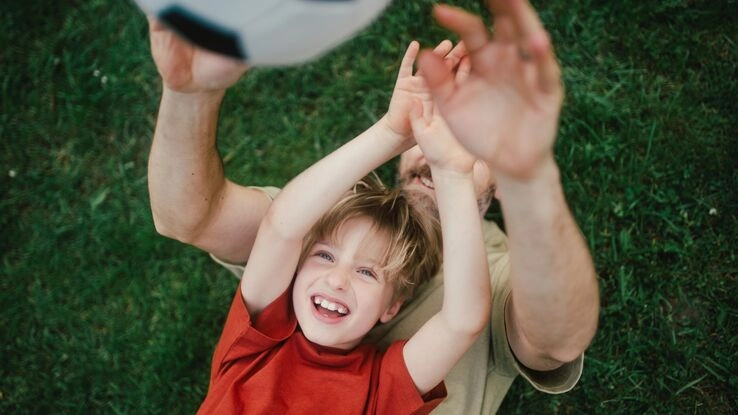 Vater und Sohn spielen Fußball.
