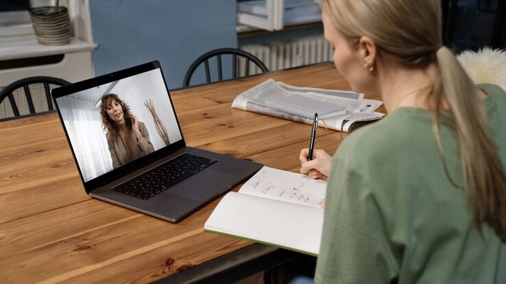 Eine Frau lässt sich von einer Beraterin virtuell zur Baufinanzierung beraten.