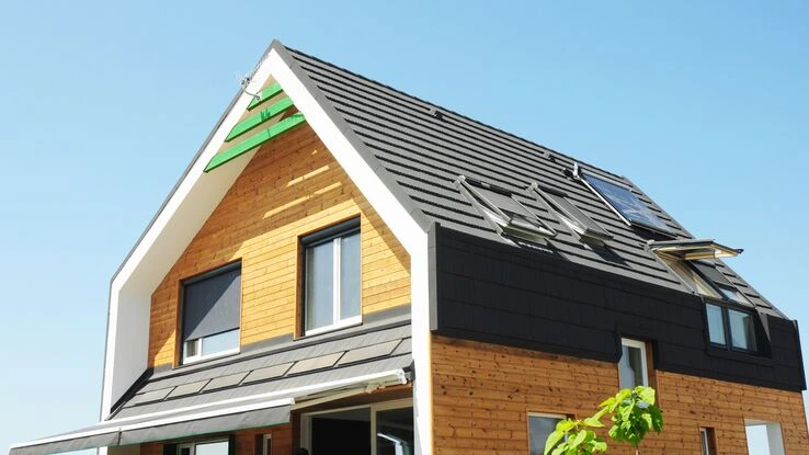 Ein Holzhaus mit einem dunklen Dach und hellem Holz.