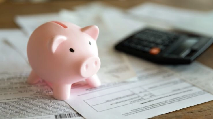 Ein Sparschwein und ein Rechner als Symbol für Kosten.