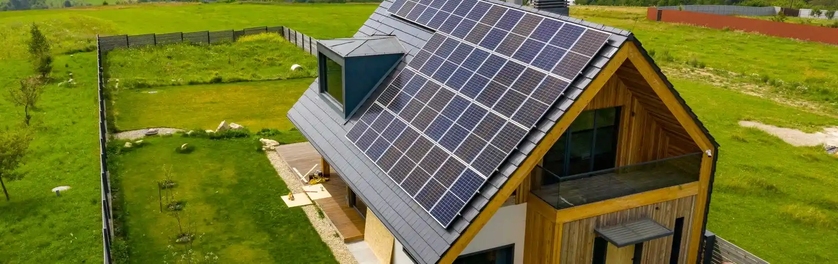 Ein freistehendes Haus auf dem Land mit Solaranlagen auf dem Dach.