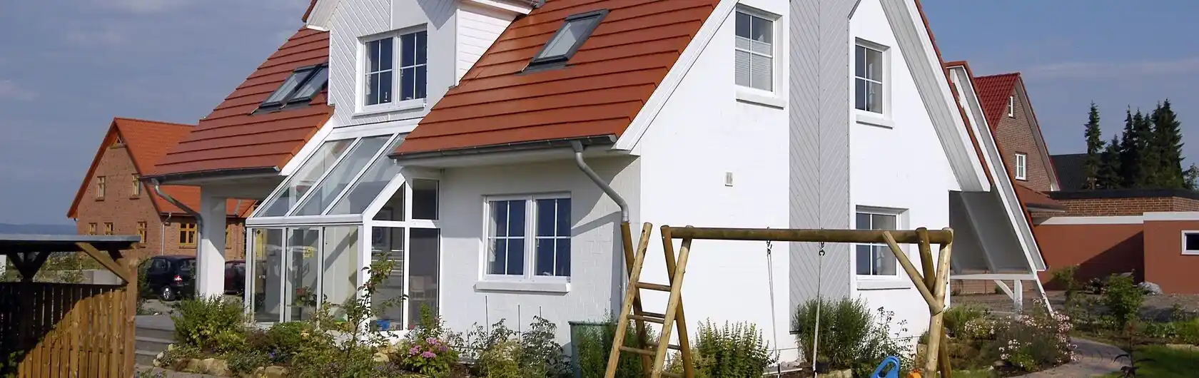Ein Einfamilienhaus mit Garten und Schaukel.