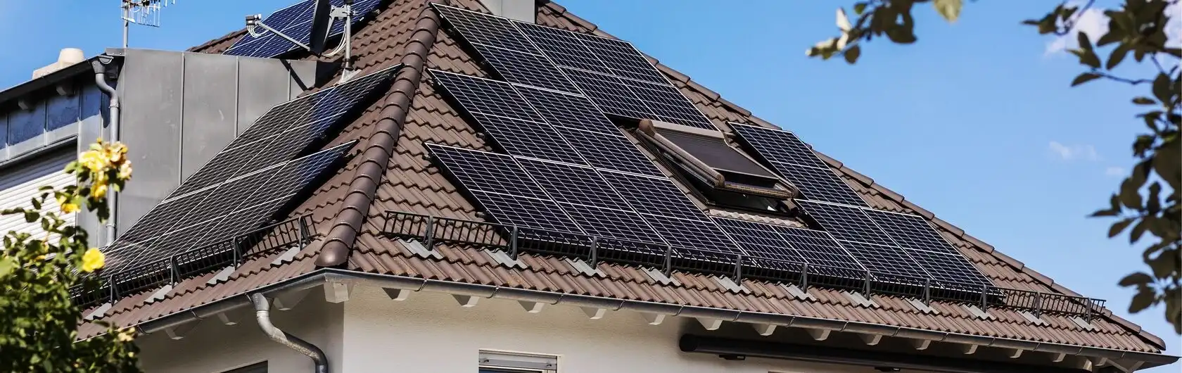 Ein Dach mit in zwei Himmelsrichtungen ausgerichtete Photovoltaikanlagen.