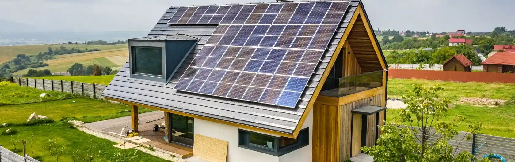 Ein kleines freistehendes Haus mit Solaranlagen auf dem Dach.