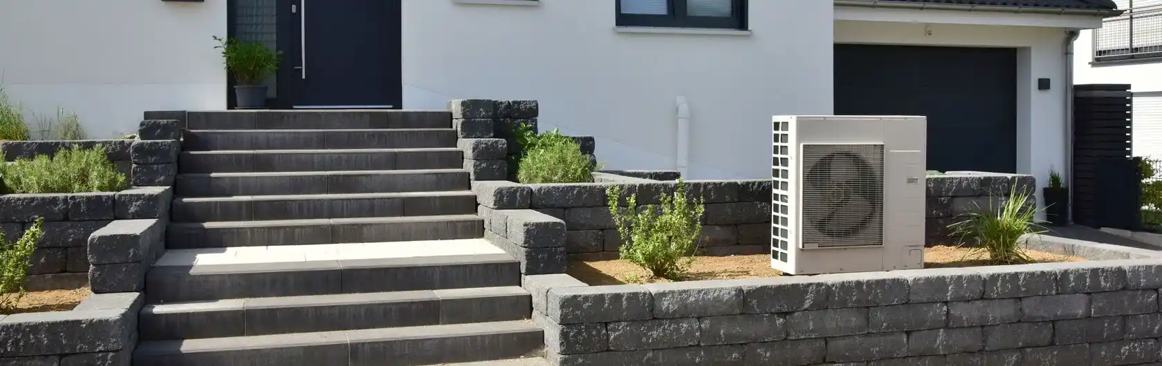 Das Bild zeigt ein modernes Haus mit einer Wärmepumpe.