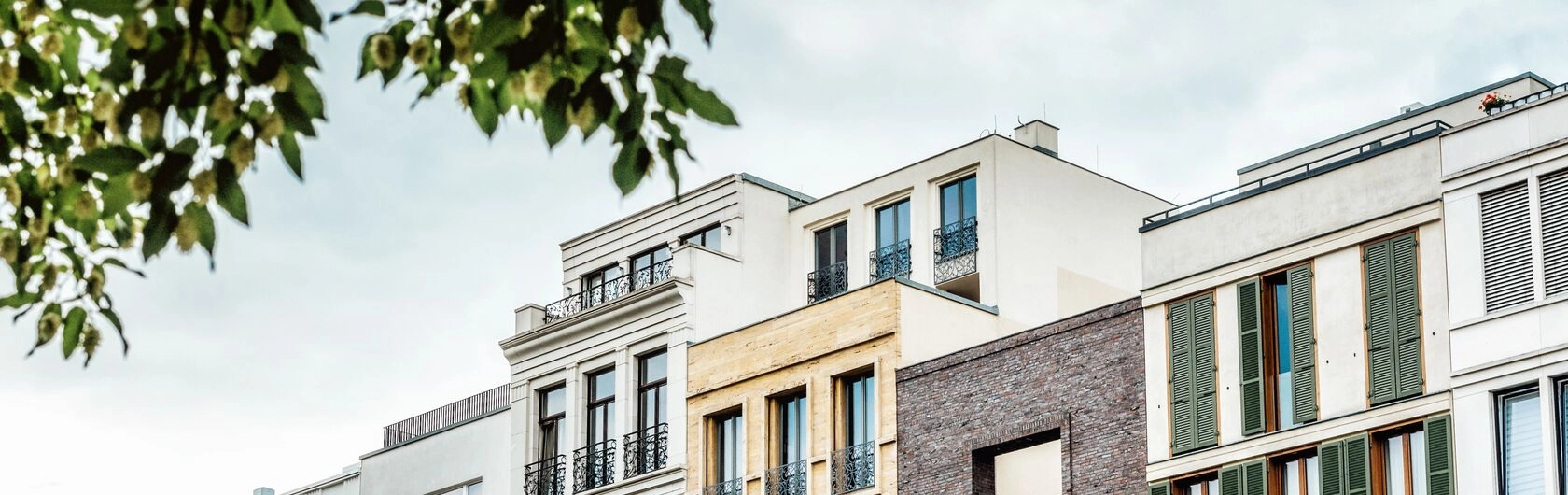 Das Foto steht sinnbildlich für das Thema Steuern bei Immobilienverkäufe und zeigt einige Reihenhäuser.