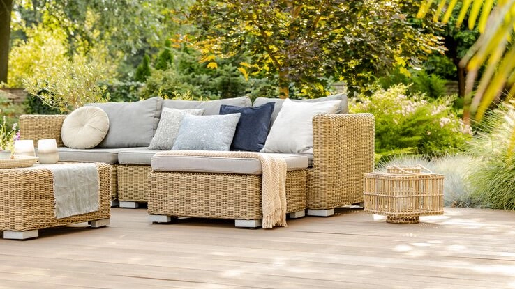 Ein gemütliches Outdoor-Sofa steht auf einer Terrasse.