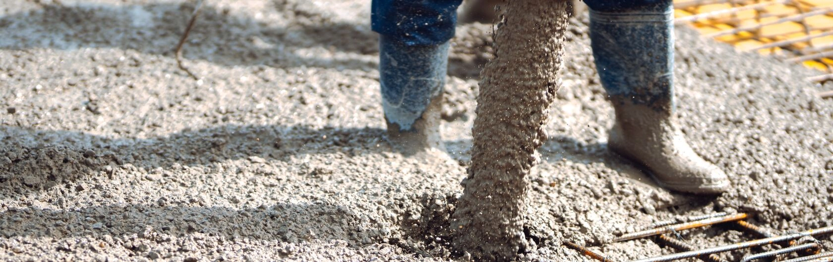 Flüssiger Beton wird ausgegossen und verteilt.