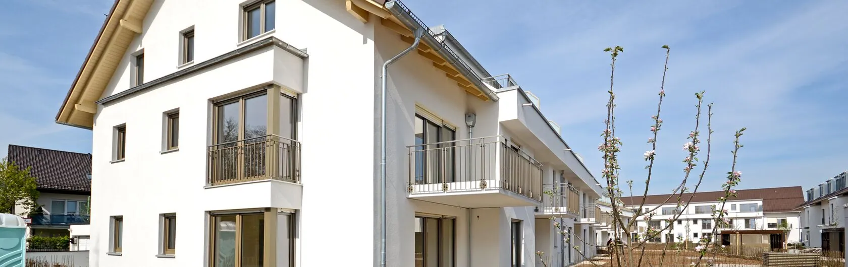 Ein modernes Mehrfamilienhaus mit Balkonen und heller Fassade.