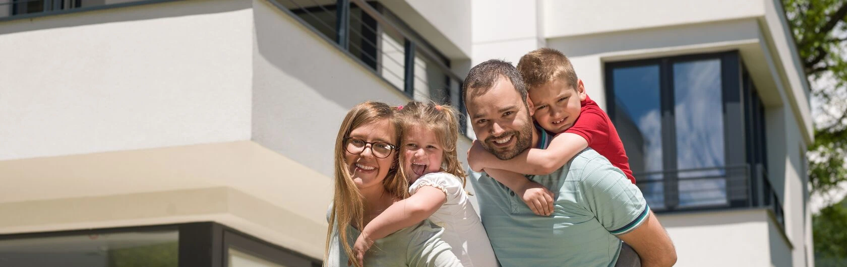 Symbolbild für KfW 124: Eine Familie vor ihrem Wohneigentum.