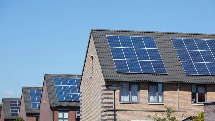 Mehrere Häuser haben auf einem Dach eine Photovoltaikanlage installiert.