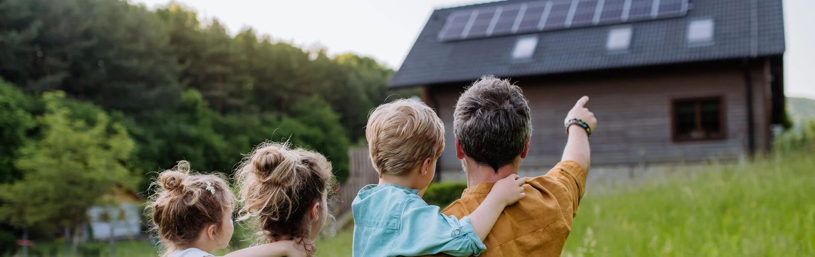 Symbolbild für KfW 308: Eine Familie schaut auf ihr Haus.