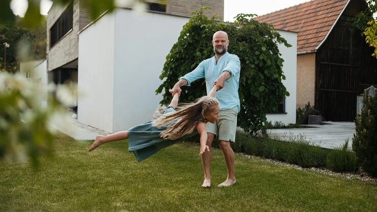 Ein Vater und seine Tochter vor Ihrem Eigenheim.