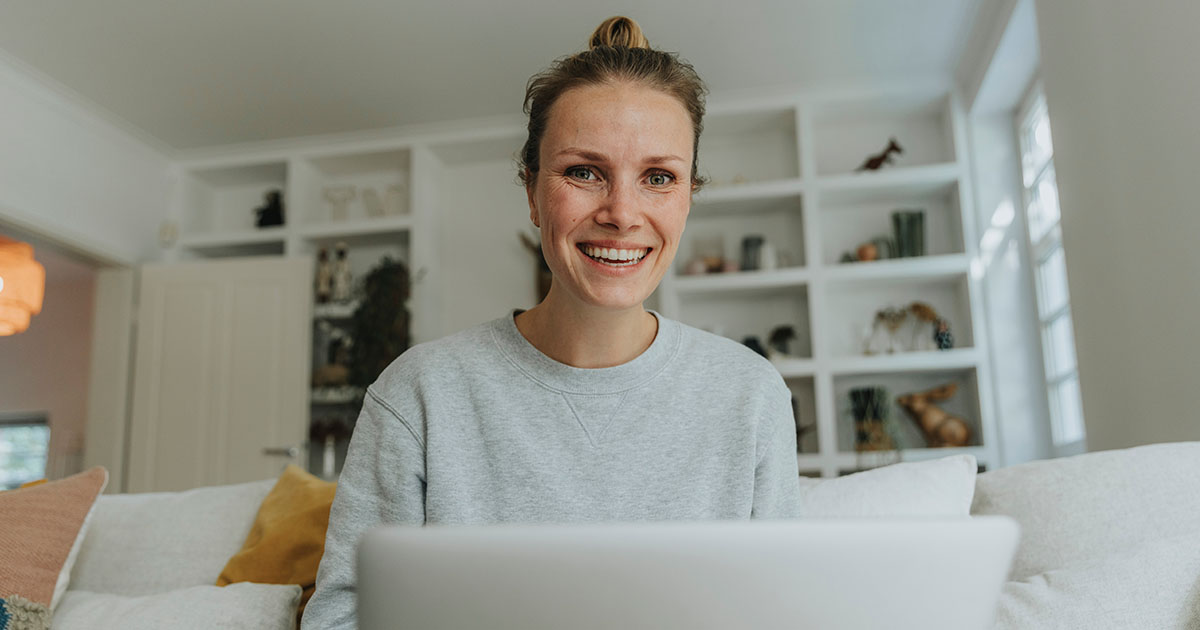 Symbolbild für den Jahreskontoauszug: Eine Frau sitzt mit ihrem Laptop auf der Couch.